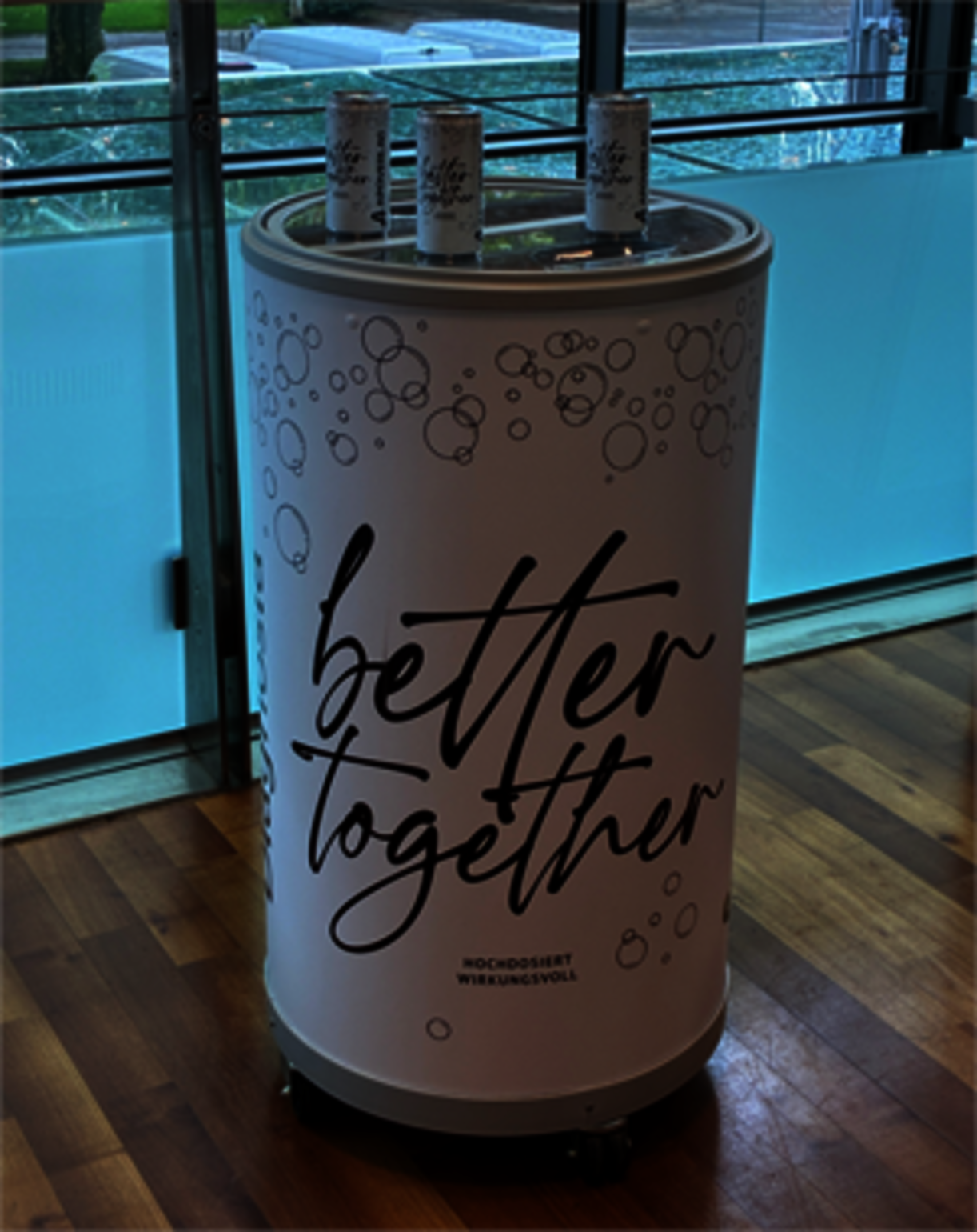 Beschriftetes rundes Pult mit drei Dosen oben drauf.