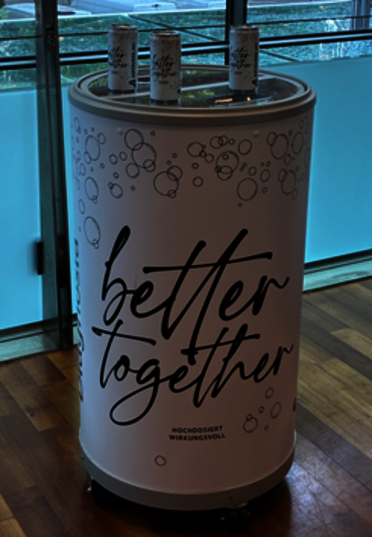 Beschriftetes rundes Pult mit drei Dosen oben drauf.