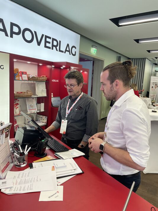 Roland Paal und Manuel Gruber stehen am AVS-Pult und sind im Gespräch.