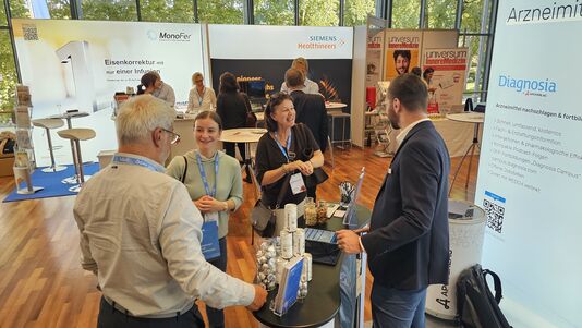 Vier Personen im Austausch, stehend an einem Pult.