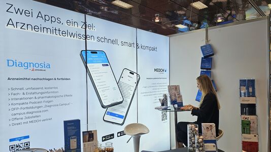 Frau sitzt auf einem Hocker mit Sicht auf eine beleuchtete Leinwand.