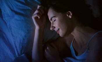 WEBINARE & VIDEOLEARNINGS: Nachtruh intens – die 3-Phasen-Innovation - Eine junge Frau schläft in Seitenlage.